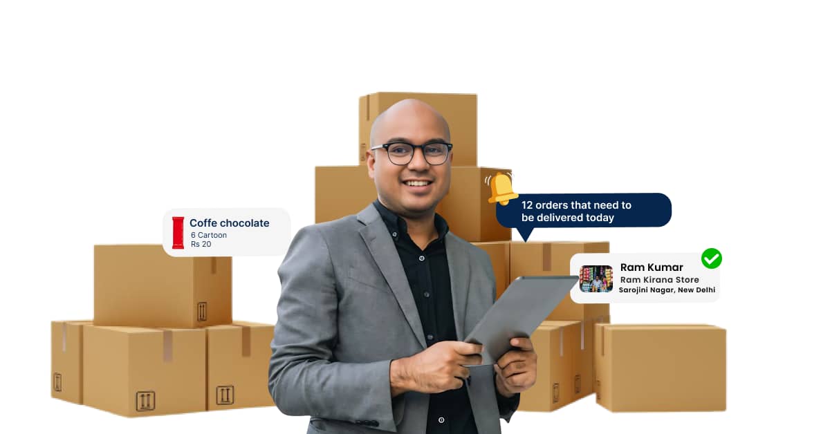 A man holding a tablet computer in front of a stack of cardboard boxes labeled with the name of a store and the address of a location in New Delhi, India. The tablet screen is displaying text that says "Coffe chocolate 6 Cartoon Rs 20" and "12 orders that need to be delivered today.